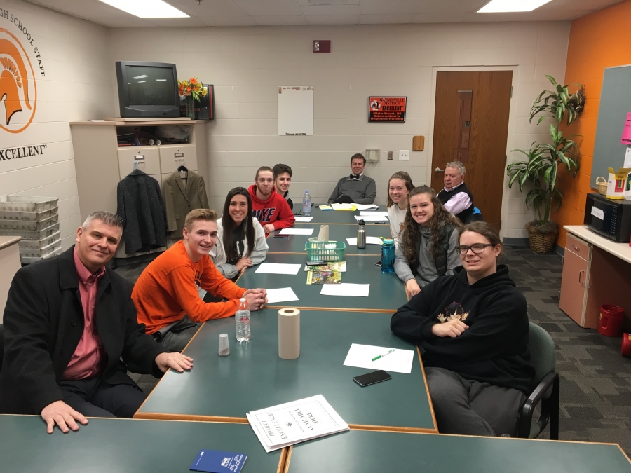 group of people sitting around board tables